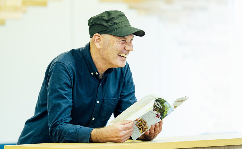 「Get Hiroshima」を手にして笑顔を見せるポールさん