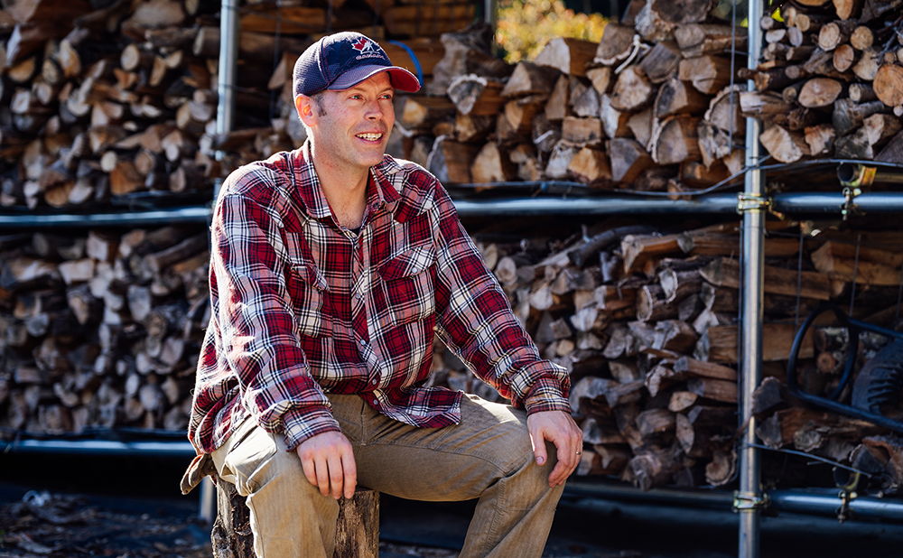 Lapierre being interviewed in front of a house full of firewood